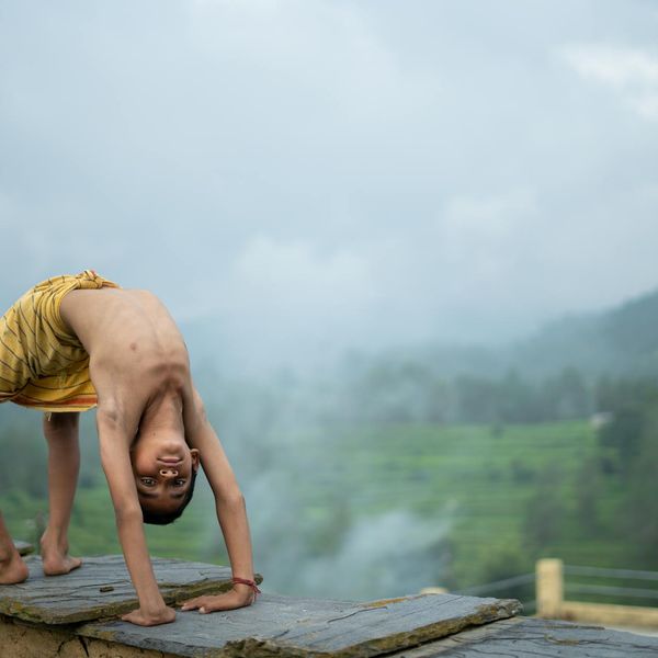 Person meditating outdoors with a peaceful nature background.