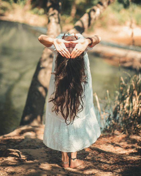 Woman performing a calm yoga pose in a bright, serene environment.